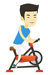 Image showing Young man riding stationary bicycle.