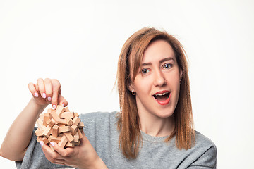 Image showing Attractive 24 year old business woman looking confused with wooden puzzle.