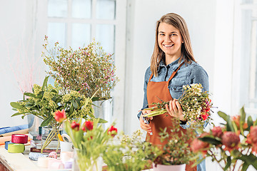 Image showing Florist at work: the young girl making fashion modern bouquet of different flowers