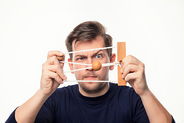 Image showing Attractive 25 year old business man looking confused at wooden puzzle.