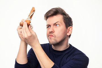 Image showing Attractive 25 year old business man looking confused at wooden puzzle.