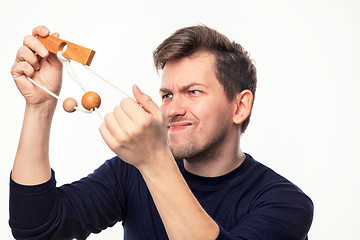 Image showing Attractive 25 year old business man looking confused at wooden puzzle.