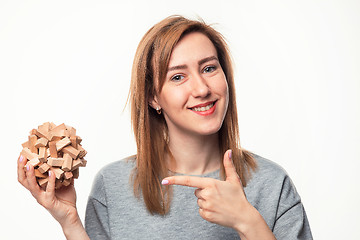 Image showing Attractive 24 year old business woman looking confused with wooden puzzle.