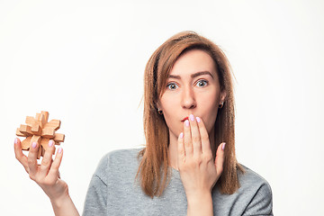 Image showing Attractive 24 year old business woman looking confused with wooden puzzle.