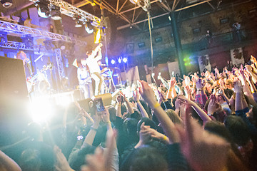 Image showing The silhouettes of concert crowd in front of bright stage lights