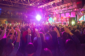 Image showing The silhouettes of concert crowd in front of bright stage lights