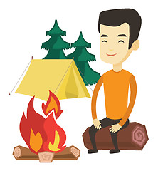 Image showing Man sitting on log near campfire in the camping.