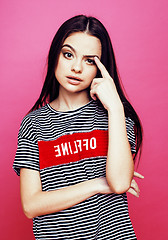 Image showing young pretty teenage woman emotional posing on pink background, fashion lifestyle people concept 