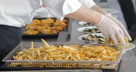 Image showing French fries and meat on the table