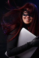 Image showing Girl in mask holds laptop