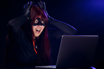 Image showing Surprised thief next to laptop