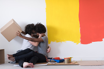 Image showing young multiethnic couple playing with cardboard boxes