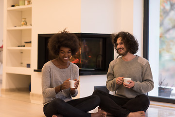 Image showing multiethnic couple  in front of fireplace