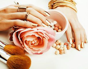 Image showing woman hands with golden manicure and many rings holding brushes, makeup artist stuff stylish, pure beauty