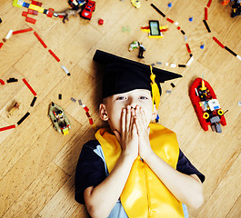 Image showing little cute preschooler boy among toys lego at home education in graduate hat smiling posing emotional, lifestyle people concept