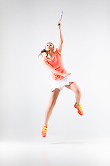 Image showing Young woman playing badminton over white background