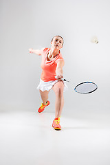 Image showing Young woman playing badminton over white background