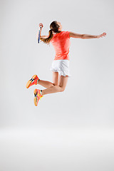 Image showing Young woman playing badminton over white background