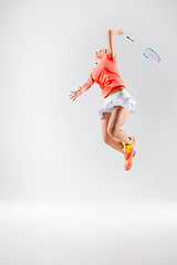 Image showing Young woman playing badminton over white background