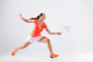 Image showing Young woman playing badminton over white background