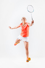 Image showing Young woman playing badminton over white background