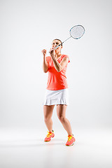 Image showing Young woman playing badminton over white background