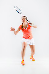 Image showing Young woman playing badminton over white background