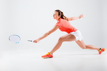 Image showing Young woman playing badminton over white background