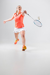 Image showing Young woman playing badminton over white background