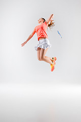 Image showing Young woman playing badminton over white background