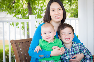 Image showing Outdoor Portrait of A Chinese Mother with Her Two Mixed Race Chi