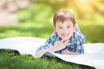 Image showing Mixed Race Chinese and Caucasian Young Boy Relaxing Outside On T