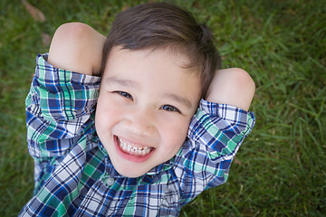 Image showing Mixed Race Chinese and Caucasian Young Boy Relaxing On His Back 