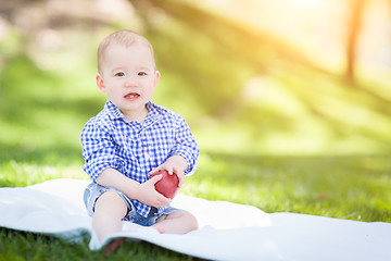 Image showing Mixed Race Infant Baby Boy Sitting on Blanket Holding Apple Outs