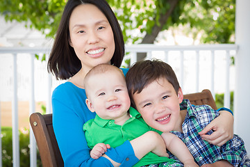 Image showing Outdoor Portrait of A Chinese Mother with Her Two Mixed Race Chi