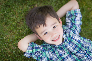 Image showing Mixed Race Chinese and Caucasian Young Boy Relaxing On His Back 