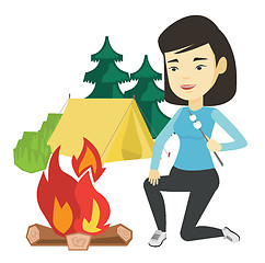 Image showing Woman roasting marshmallow over campfire.