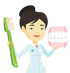 Image showing Dentist with dental jaw model and toothbrush.