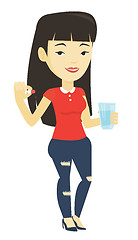 Image showing Young asian woman taking pills.