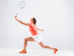 Image showing Young woman playing badminton over white background