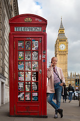 Image showing Woman talking on mobile phone, red telephone box and Big Ben. London, England