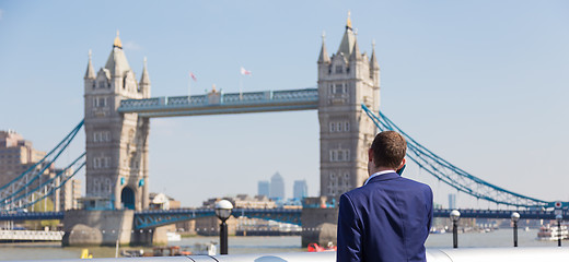 Image showing British businessman talking on mobile phone outdoor in London city, UK.