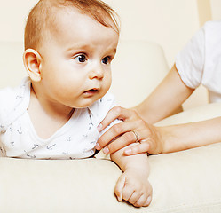 Image showing little cute toddler baby boy playing on chair, mother insures holding hand, lifestyle people concept 