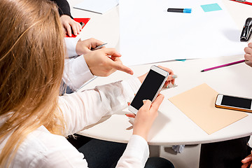 Image showing The woman sitting behind desk, checking reports, talking.