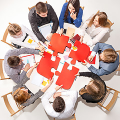 Image showing Team sitting behind desk, checking reports, talking. Top View