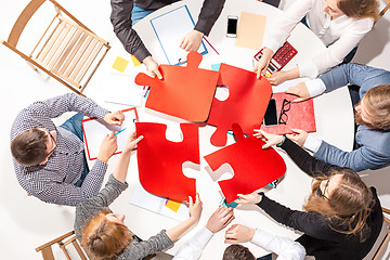 Image showing Team sitting behind desk, checking reports, talking. Top View