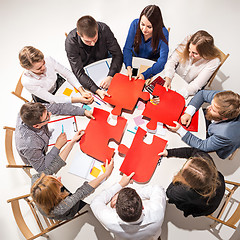 Image showing Team sitting behind desk, checking reports, talking. Top View