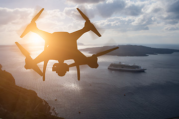 Image showing Unmanned Aircraft System (UAV) Quadcopter Drone In The Air At Su