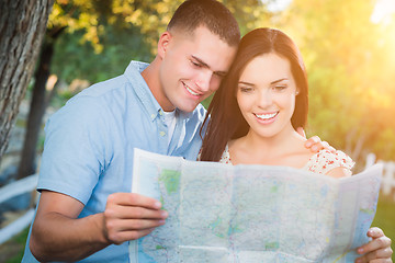 Image showing Happy Mixed Race Couple Looking Over A Map Outside Together.