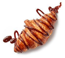 Image showing freshly baked croissant decorated with chocolate sauce